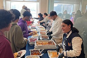 Staff serve a meal to students and families at MS 303.