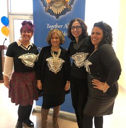 Four District 9 staff members in matching black shirts at a Together All Is Possible event
